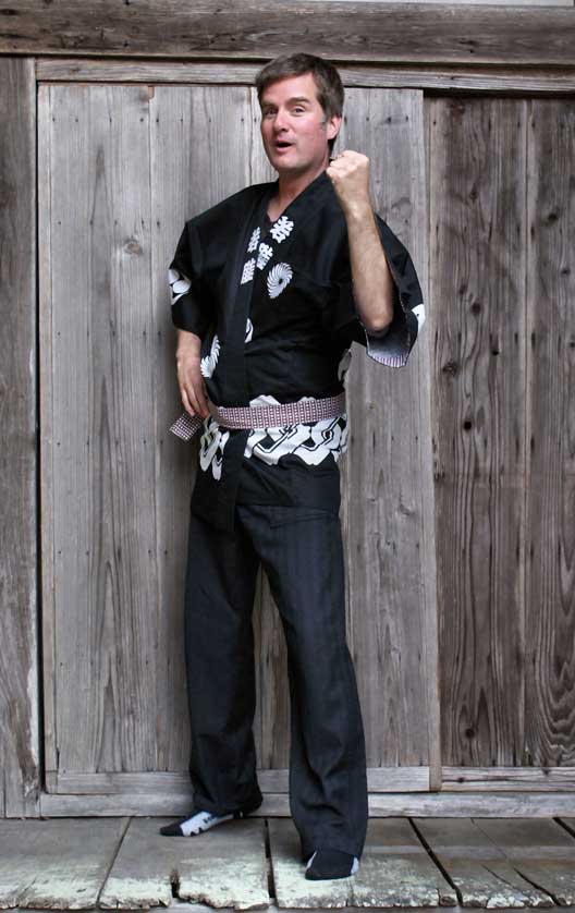 Model wearing a traditional black happi with obi belt.