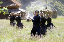 Katsumoto's band of samurai practice their katas (sword strokes).