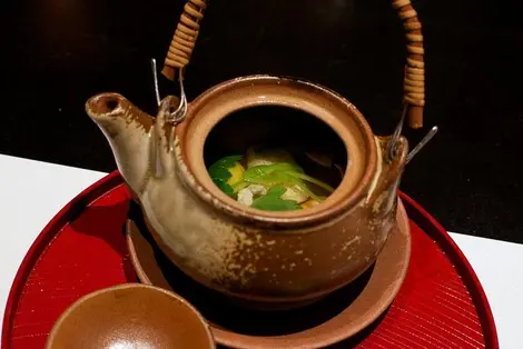 Le bouillon de la soupe Matsutake Dobin Mushi servit dans sa tellière. 