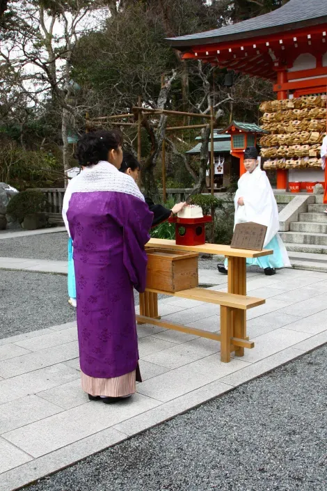 Une femme vient planter son aiguille dans un bloc de tofu pendant Hari Kuyo, la cérémonie pour honorer les aiguilles usagées