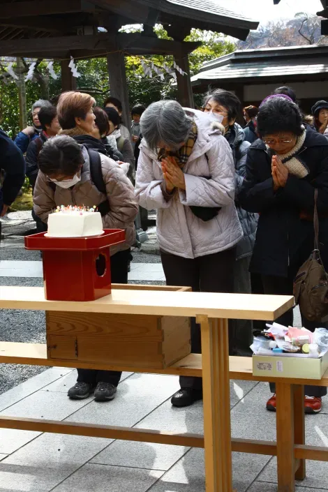 Des femmes priant devant le bloc de tofu utilisé pendant Hari Kuyo, la cérémonie pour honorer les aiguilles usagées