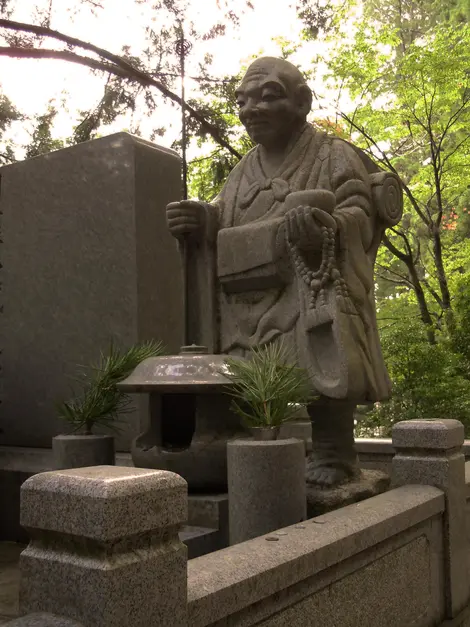 La statue d'un moine bouddhiste portant le juzu à la main