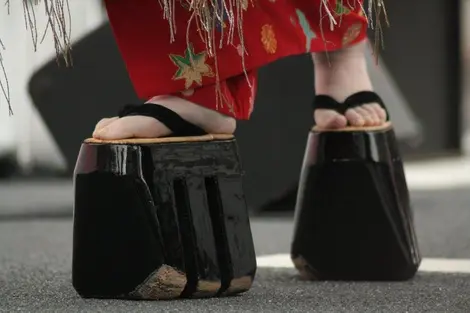 Les oiran effectuent la marche "hachimonji" pour se déplacer, sur leurs sanmaiba geta (soques de bois traditionnelles) 