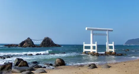 Les rochers mariés Meoto Iwa et le grand Torii blanc depuis la plage d'Itoshima